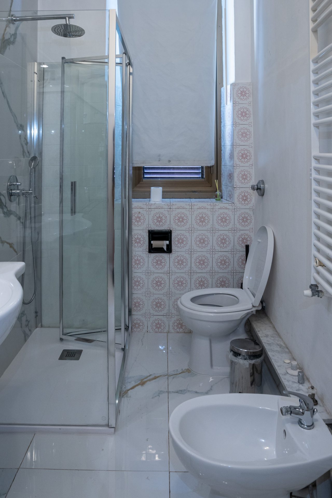 Wc e bidet affiancati con doccia angolare e finestra nel bagno dell'hotel
