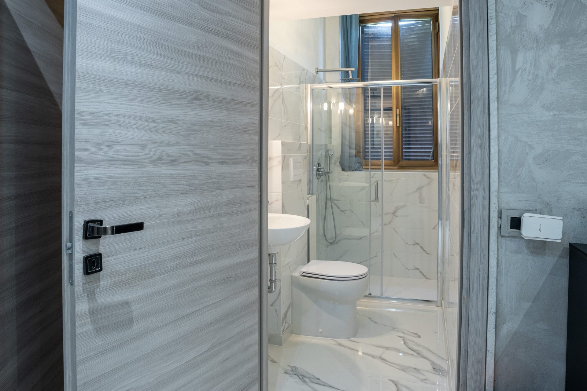 Bagno di camera d'albergo visto dalla porta d'ingresso dopo la ristrutturazione